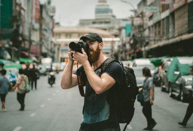 Street photographer shooting in the middle of a busy city road