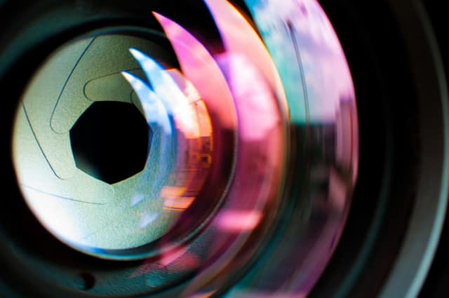 Extreme close-up of lens aperture blades with iridescent reflections